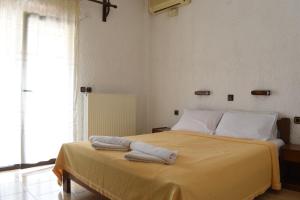 1 dormitorio con 1 cama con 2 toallas en Hotel Lefkes, en Paralía Skotínis