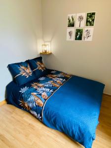 a bed with blue sheets and pictures on the wall at Esprit Cosy Centre Ville in Roanne