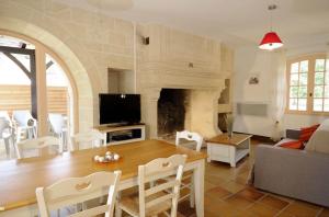 Una sala de estar con una mesa y una chimenea. en Le Clos des Rives, en Saint-Vincent-de-Cosse