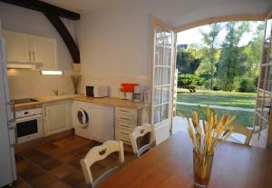 cocina con mesa y sillas y ventana grande en Le Clos des Rives, en Saint-Vincent-de-Cosse