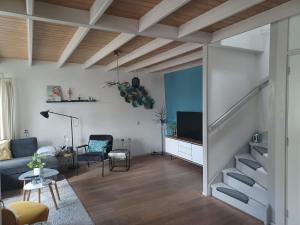 een woonkamer met een bank en een tv bij Karakteristiek huis in centrum Winsum met nieuwe badkamer in Winsum