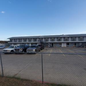 a parking lot with cars parked in front of a building at Motel 9 in Laredo