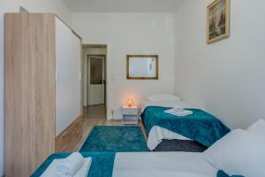 a small bedroom with two beds and a mirror at Buenas Noches in Split