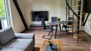 ein Wohnzimmer mit einer Couch, einem Tisch und einem Fernseher in der Unterkunft Bahnhof Gleis 72 - Ferienwohnungen in Timmenrode