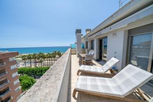 un balcón con 2 tumbonas y el océano en HomeHolidaysRentals Blaucel - Costa Barcelona en Pineda de Mar