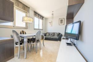 Sala de estar con mesa de comedor y TV en HomeHolidaysRentals Blaucel - Costa Barcelona en Pineda de Mar