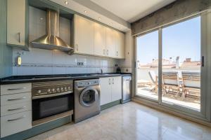 cocina con lavadora y secadora y balcón en HomeHolidaysRentals Blaucel - Costa Barcelona en Pineda de Mar