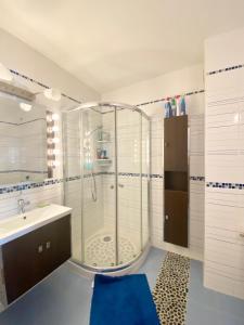 uma casa de banho com um chuveiro e um lavatório. em Appartement bord de mer, Bénodet em Bénodet