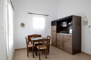 a kitchen and dining room with a table and a microwave at Astrio Suites in Livadi +65 photos