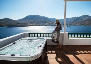 a woman standing in a bath tub on a balcony at Astrio Suites in Livadi