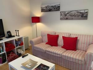 a living room with a couch and red pillows at Casa da Foz in Porto