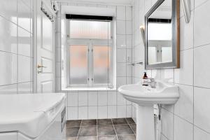 a white bathroom with a sink and a mirror at Central bus station apartment, wifi, tv in Narvik
