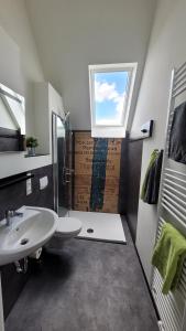 ein Badezimmer mit Waschbecken und Toilette und einem Fenster in der Unterkunft Bahnhof Gleis 72 - Ferienwohnungen in Timmenrode + 25 Fotos