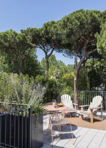 eine Terrasse mit einem Tisch, Stühlen und Bäumen in der Unterkunft Antica Dimora Le Misure in Cervia