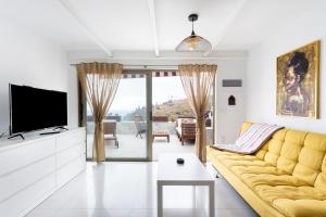 ロス・レアレホスにあるEl Castro Apartment, Amazing Ocean & Cliff Viewのリビングルーム(黄色のソファ、テレビ付)