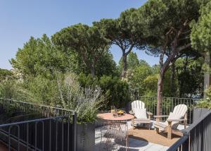 a patio with a table and chairs and trees at Antica Dimora Le Misure in Cervia
