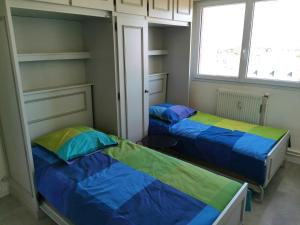 2 Betten in einem Zimmer mit 2 Fenstern in der Unterkunft Le Foch - Appartement face mer avec garage in Les Sables-dʼOlonne