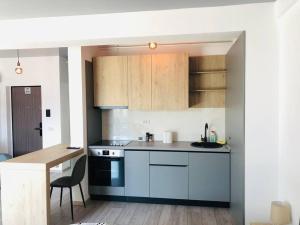 a kitchen with white cabinets and a table in it at DXN Luxury Studio in Năvodari