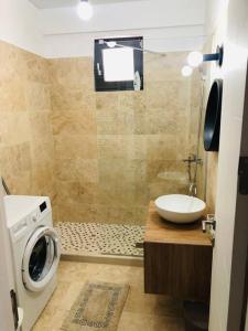 a bathroom with a washing machine and a sink at DXN Luxury Studio in Năvodari +1 photo