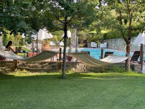 Gatto Bianco Tizzauli في مونتيزبيرتولي: اثنين من الأراجيح في ساحة بجوار حمام السباحة