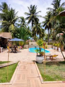 um resort com piscina e palmeiras em Pousada Recanto dos Milagres em São Miguel dos Milagres