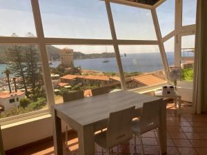 a table and chairs in a room with a large window at Vetrata sul mare in Campese