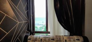 ventana en una habitación con cama y cortina en Квартира 14 мкр 17 дом на побережье, en Aktau