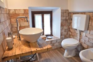 a bathroom with a bowl sink and a toilet at Camera a Casa Castora in Uffogliano +34 photos