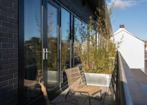 two chairs sitting on a balcony with glass doors at Custom House Apartments in Newry