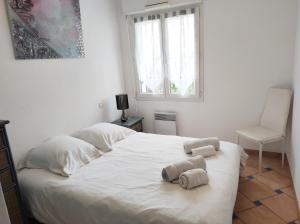 a bedroom with a white bed with towels on it at Port marine appartement 3 pièces avec piscine in Sainte-Maxime