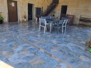 een patio met een tafel en stoelen op een stenen vloer bij Casa Maral in Pontevedra