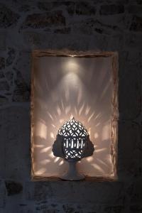 a light in a window in a brick wall at white room Ostuni in Ostuni