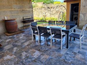 eine Terrasse mit einem Tisch und Stühlen auf einem Steinboden in der Unterkunft Casa Maral in Pontevedra