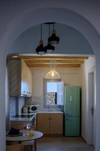 a kitchen with a green refrigerator and a table at Acro Blue Luxury Villas in Akrotiri
