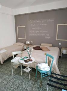 a bedroom with two beds and a chalkboard on the wall at Le Dimore degli Artisti in Venosa