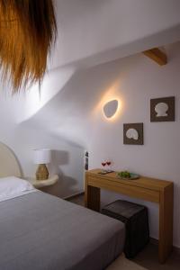 a bedroom with a bed and a wooden table at Acro Blue Luxury Villas in Akrotiri