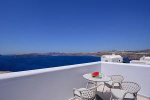 una mesa y sillas en un balcón con vistas al océano en Acro Blue Luxury Villas, en Akrotiri