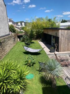 een tuin met een hangmat en een aantal planten bij Adorable guest house au calme à 3 min du port in Vannes