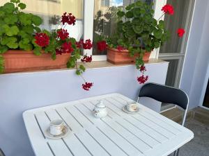 un tavolo bianco e una sedia con due tazze sopra di Апартамент Иванови a Pomorie