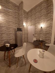 una stanza con tavoli e sedie e un muro di mattoni di The Passenger Rooms a Tbilisi City
