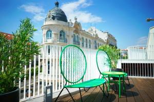 twee groene stoelen voor een gebouw bij Vila Intendente - Apartamento 2 Quartos in Lissabon