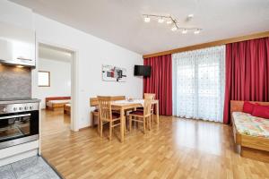エック・アム・ファーカー・ゼーにあるApartments Weberhofのテーブルと椅子のあるキッチンとリビングルーム