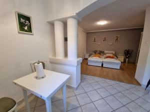 - un salon avec une table blanche et une cheminée dans l'établissement Magic Garten, à Hévíz