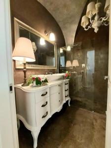 La salle de bains est pourvue d'un lavabo blanc et d'un miroir. dans l'établissement Atelier di Birbiciú, à Cianciana