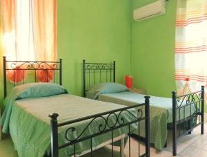 庫佩洛的住宿－Casa Vacanze e B&B In Piazza，绿墙客房内的两张床