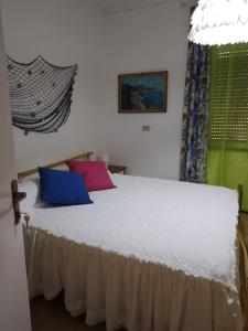 ein Schlafzimmer mit einem Bett mit zwei Kissen darauf in der Unterkunft Palazzo tre palme in Follonica