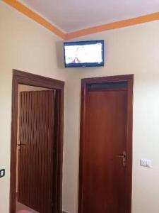 una camera con una porta e una televisione sul soffitto di Il Mare di Elea ad Ascea