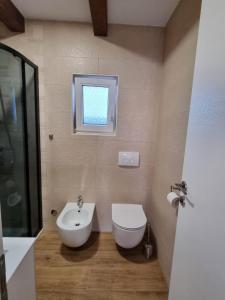 a bathroom with a sink and a toilet and a window at Holiday house Adriana in Povljana