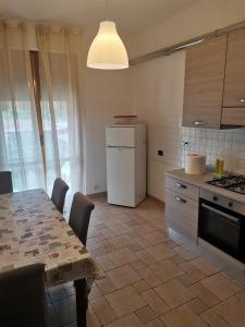 a kitchen with a table and a white refrigerator at Appartamento Scarperia San Piero a Sieve in San Piero a Sieve