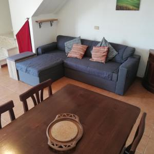 a living room with a blue couch and a table at Rustico Lo Scarpone in Camaiore